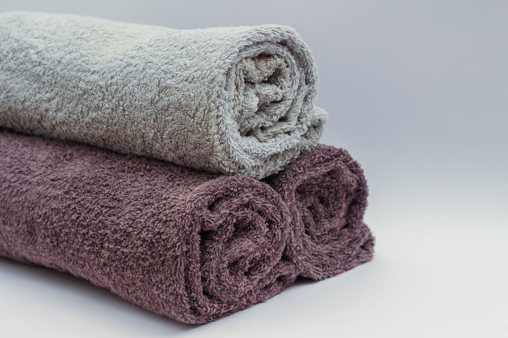 Close-up of rolled bathroom towels in neutral tones, ideal for interior design or spa themes.